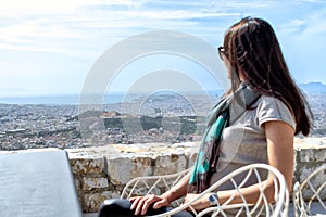 Woman is looking on a big city Athens and the Acropolis hill.