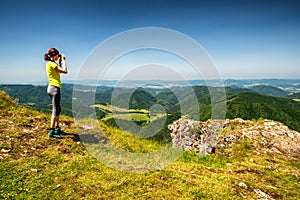 Žena při pohledu dalekohledem na krásné horské krajiny. Vrch Strážov, Slovensko