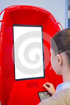 Woman looking at blank white display kiosk at exhibition - white screen concept