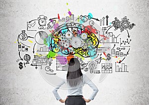 Woman looking at brain and gears on concrete