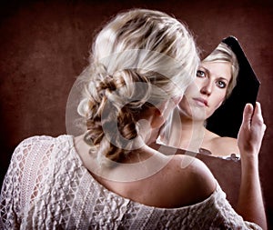 Woman looking into a broken mirror