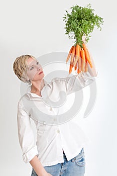 Woman looking at a bunch of carrots