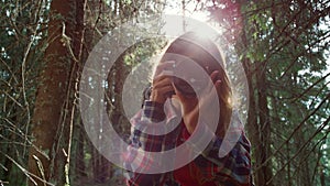 Woman looking at camera. Female photographer taking photos of forest landscape