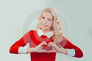 Woman looking at camera through heart gesture