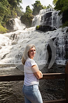 Woman with her back to the camera on a pier looking at the Pancada Grande waterfall. Environment photo