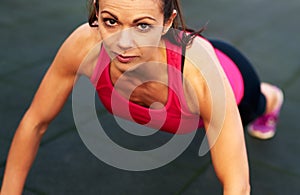 Woman looking at camera in a push up stance.