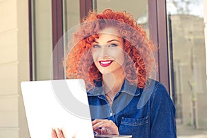 Woman looking at camera using laptop computer