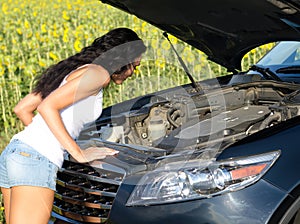 Woman looking into car engine