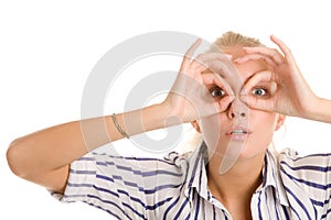 Woman looking through circled fingers