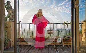 Woman looking at city from a balcony in early morning