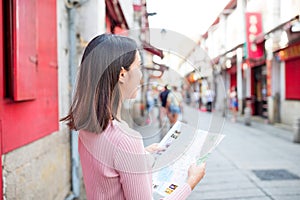 Woman looking at city map in Rua da Felicidade of Macao city photo