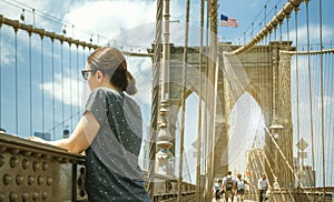 Woman looking cityscape from Brooklyn Bridge in New York City