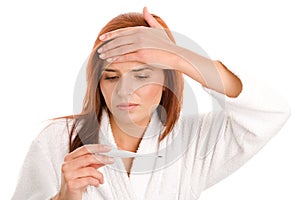 Woman looking at clinical thermometer