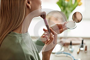 Woman Looking in Compact Mirror by Window