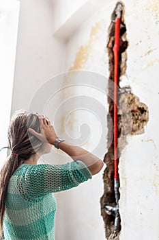 Woman looking at damage after a water pipe leak