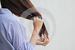 Woman looking at damaged splitting ends of hair, Haircare concept