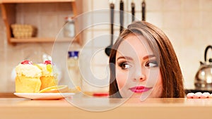 Woman looking at delicious sweet cake. Gluttony.