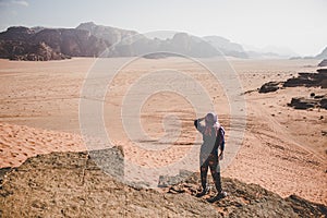 Woman looking on desert moody dramatic dry landscape in smoke from cliff edge top view point, climate changes global warming