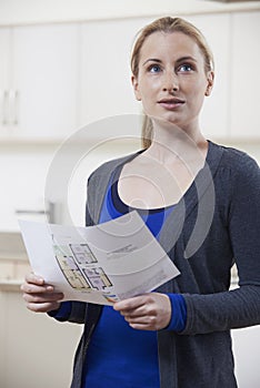 Woman Looking At Details For Property She Hopes To Buy