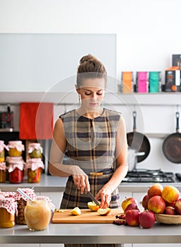 Woman looking down while cutting apples in kitchen