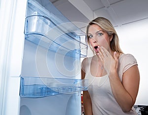 Woman Looking In Empty Fridge