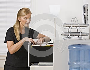 Woman Looking Through Filing Cabinet