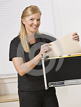 Woman Looking Through Filing Cabinet