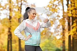 Woman looking at fitness tracker in autumn park