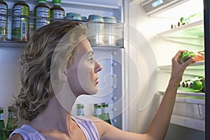 Woman Looking For Food In Refrigerator