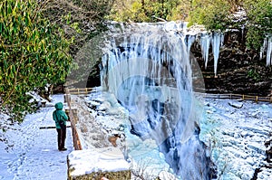 Woman Looking at a Frozen Waterfall