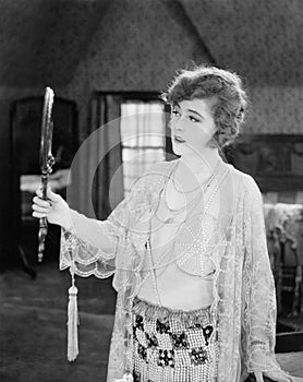 Woman looking in hand mirror