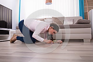 Woman Looking At Hardwood Floor Through Magnifying Glass