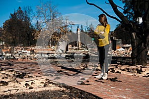 Woman looking at her burned home after fire disaster