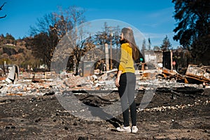 Woman looking at her burned home after fire disaster