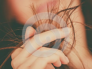 Woman looking at her dry hair ends