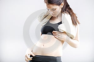 Woman looking at her flat stomach after training