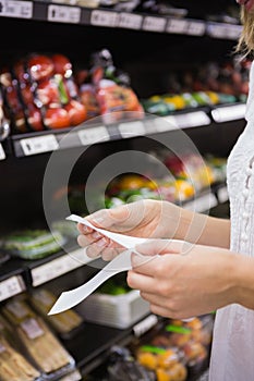 A woman looking at her grocery list