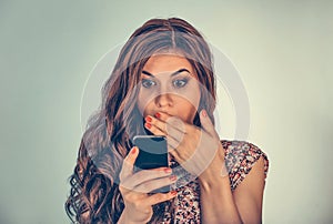 Woman looking at her phone with shocked