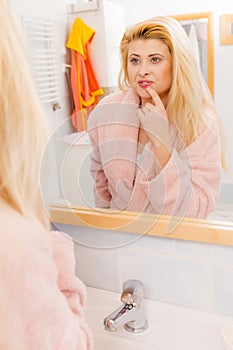 Woman looking at her reflection in mirror