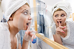 Woman looking at her reflection in mirror