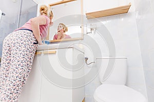 Woman looking at her reflection in mirror