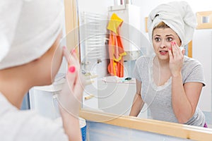 Woman looking at her reflection in mirror