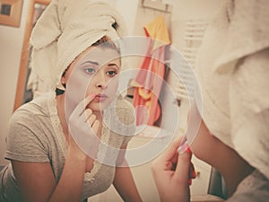 Woman looking at her reflection in mirror