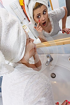 Woman looking at her reflection in mirror