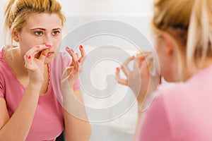 Woman looking at her reflection in mirror