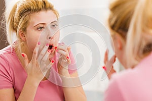 Woman looking at her reflection in mirror