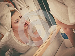 Woman looking at her reflection in mirror