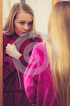 Woman looking at her reflection in mirror