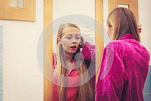 Woman looking at her reflection in mirror