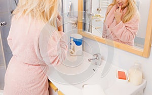 Woman looking at her reflection in mirror